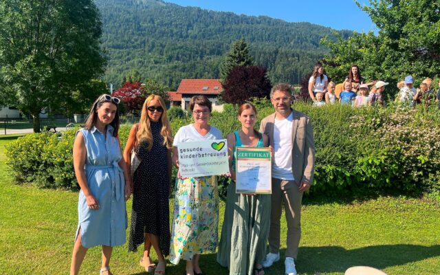 Kinder im Kindergarten Feffernitz gärtnern an Hochbeeten und spielen im Freien.