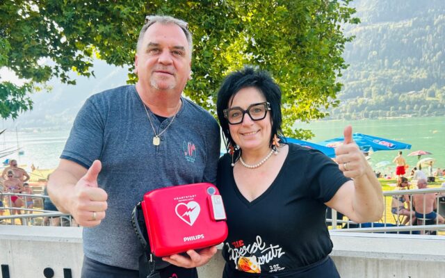 Michaela und und Michael Kopeinig vom Strandbuffet mit dem Defibrillator, der sich zur freien Entnahme im Bereich der Sitztische vor dem Bistro befindet.