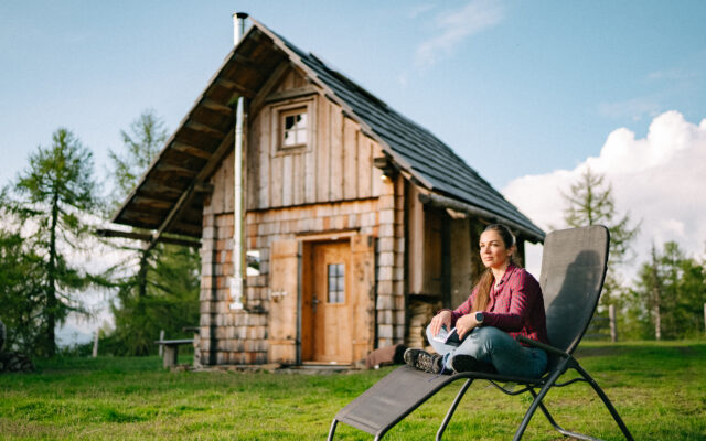 Kärntner Bergbauernhof mit Almhütte, grünen Wiesen und Bergen im Sommer