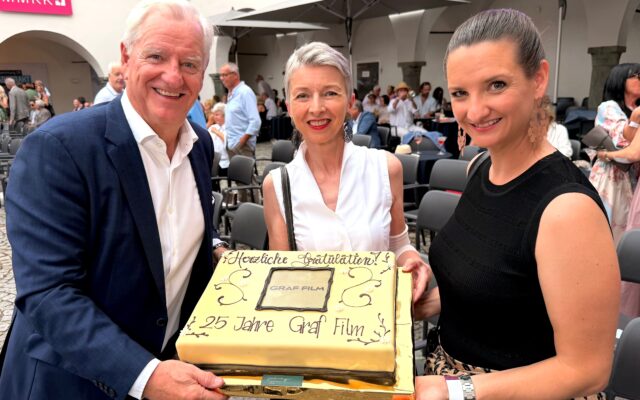 LHStv.in Gaby Schaunig überreicht die Geburtstagstorte an Klaus Graf, Geschäftsführer und Produzent und Livia Graf-Bechler Geschäftsführerin Graf Film, Produzentin und Green Film Consultant