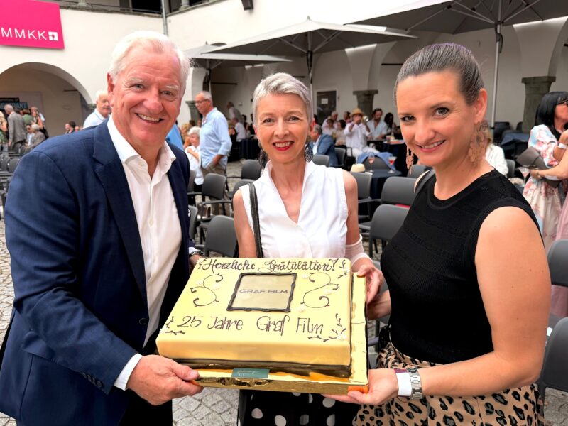 LHStv.in Gaby Schaunig überreicht die Geburtstagstorte an Klaus Graf, Geschäftsführer und Produzent und Livia Graf-Bechler Geschäftsführerin Graf Film, Produzentin und Green Film Consultant